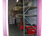 Warehouse racks set up in secure storage area with first load of exhaust systems loaded